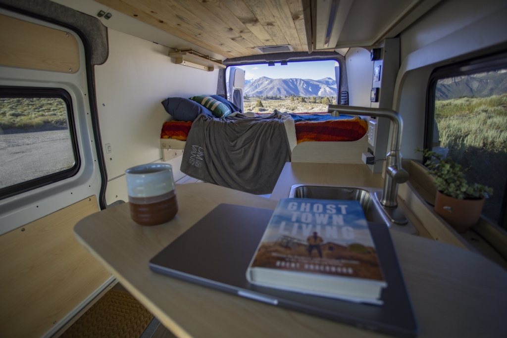 reading and coffee in a ram promaster campervan